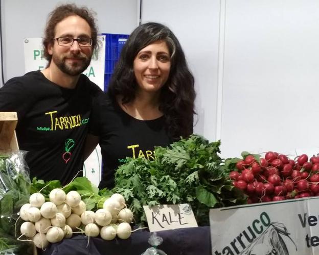 Andras Hajdu y María Leal, posan junto a algunas de las verduras que cultivan.