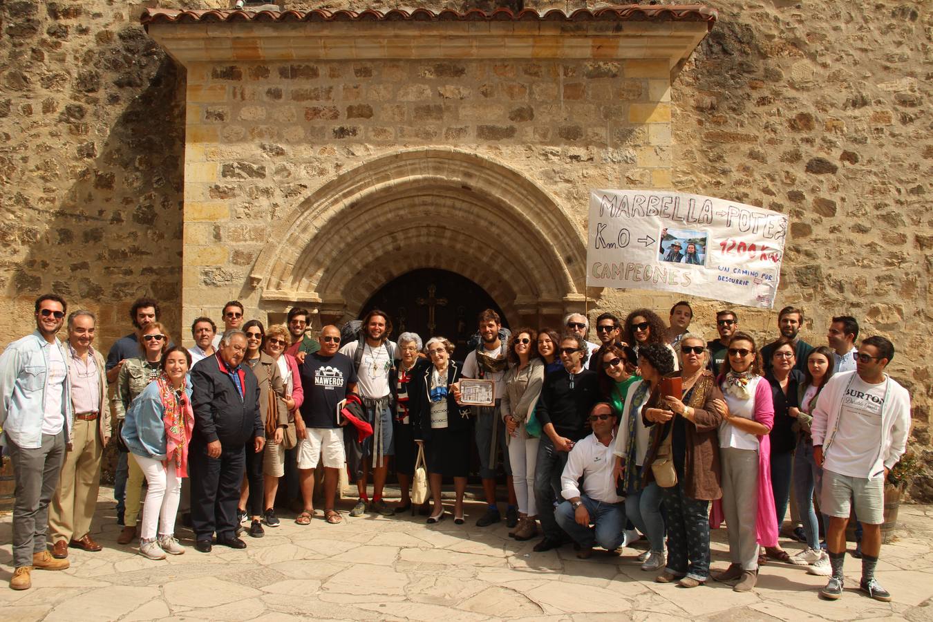 Adrián y Andrea posan con sus familiares junto a la puerta del Perdón en el monasterio de Santo Toribio.