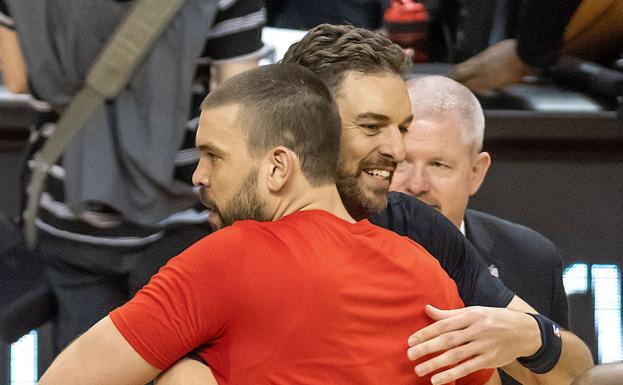 Pau y Marc Gasol se abrazan antes de un partido entre los equipos de ambos.