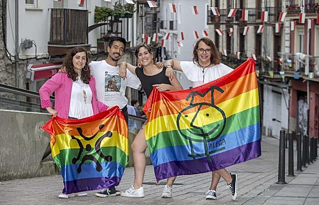 De izquierda a derecha, Kiara, Jonathan, Alba y Meredy posan juntos con la bandera arcoíris que representa al colectivo LGTB. 