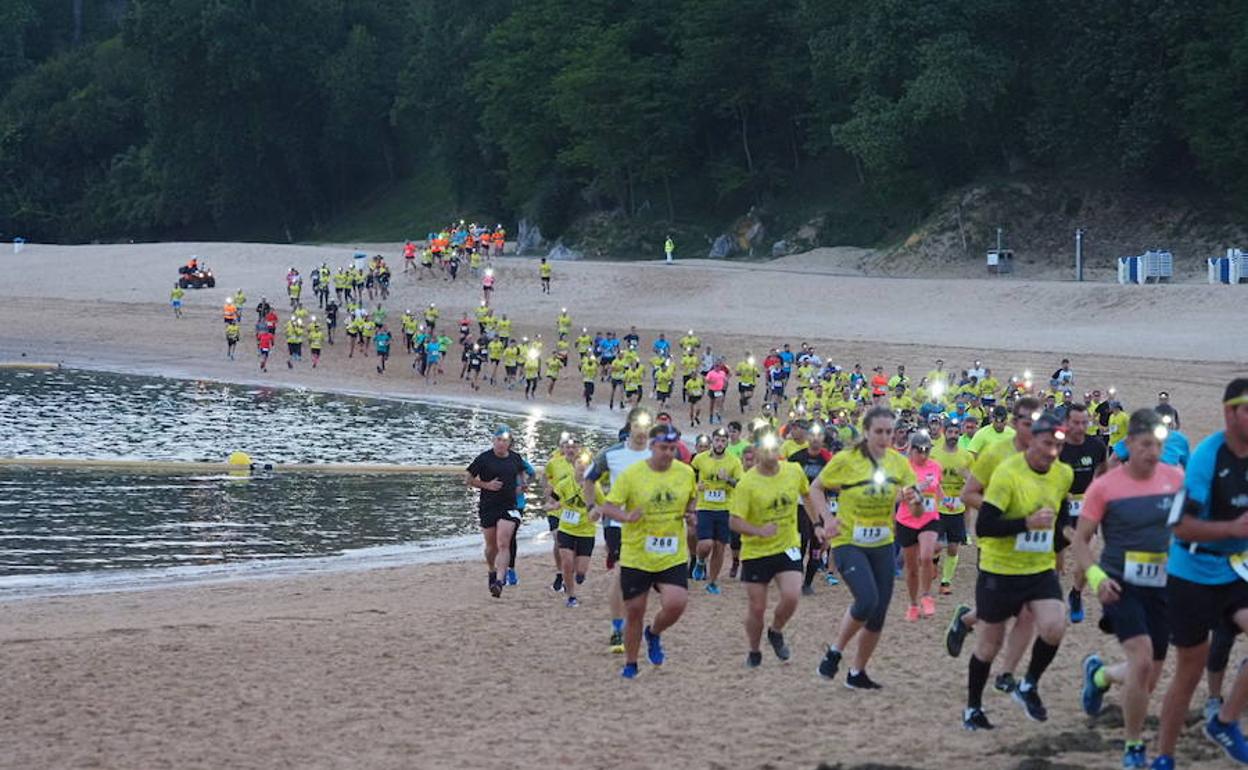 Los participantes en el trail, a su paso por la playa de La Magdalena.