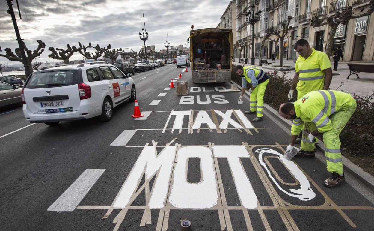 Imagen de archivo de varios operarios pintando Taxi y Moto en el carril del metro TUS en el Paseo de Pereda en enero de 2018.