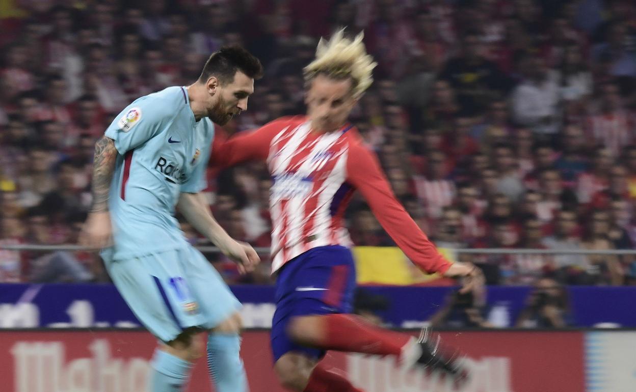 Leo Messi pugna por un balón con Antoine Griezmann
