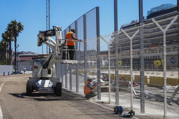 Varios operarios trabajan en las obras de la valla del puerto en el tramo de la calle Antonio López frente al crucero 'Arcadia'.