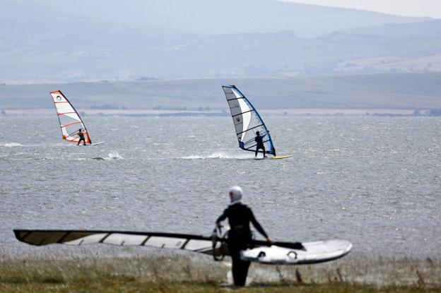 Unos windsurfistas navegan por las aguas del pantano del Ebro, donde el viento puede soplar con una fuerza de hasta 25 nudos. 