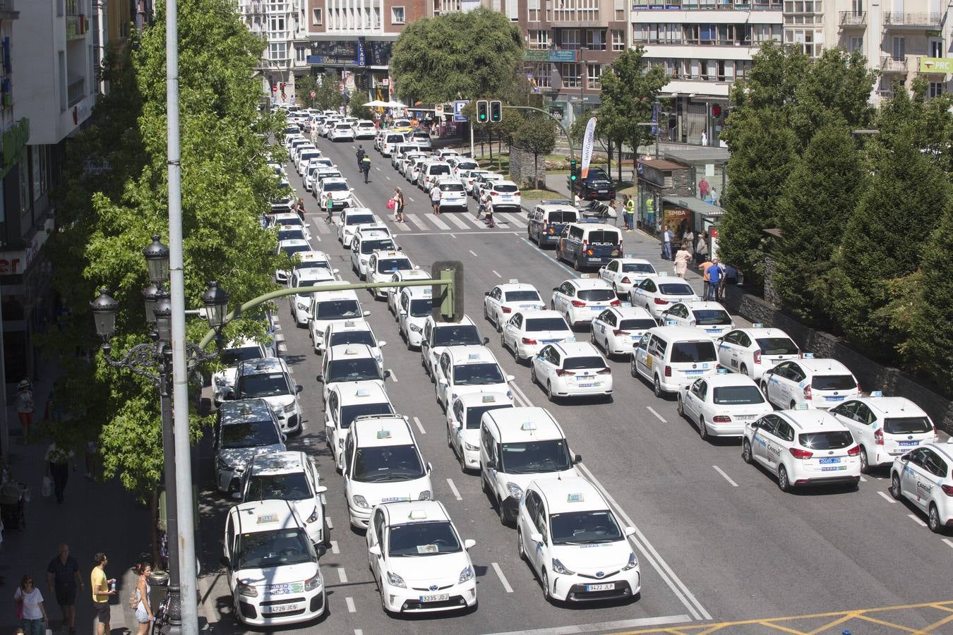 Efectivos de la Policía Local de Santander y los taxistas se han unido hoy para cortar la calle Jesús de Monasterio y paralizar el centro de la ciudad a mediodía para reclamar al Ayuntamiento que atienda sus reivindicaciones.