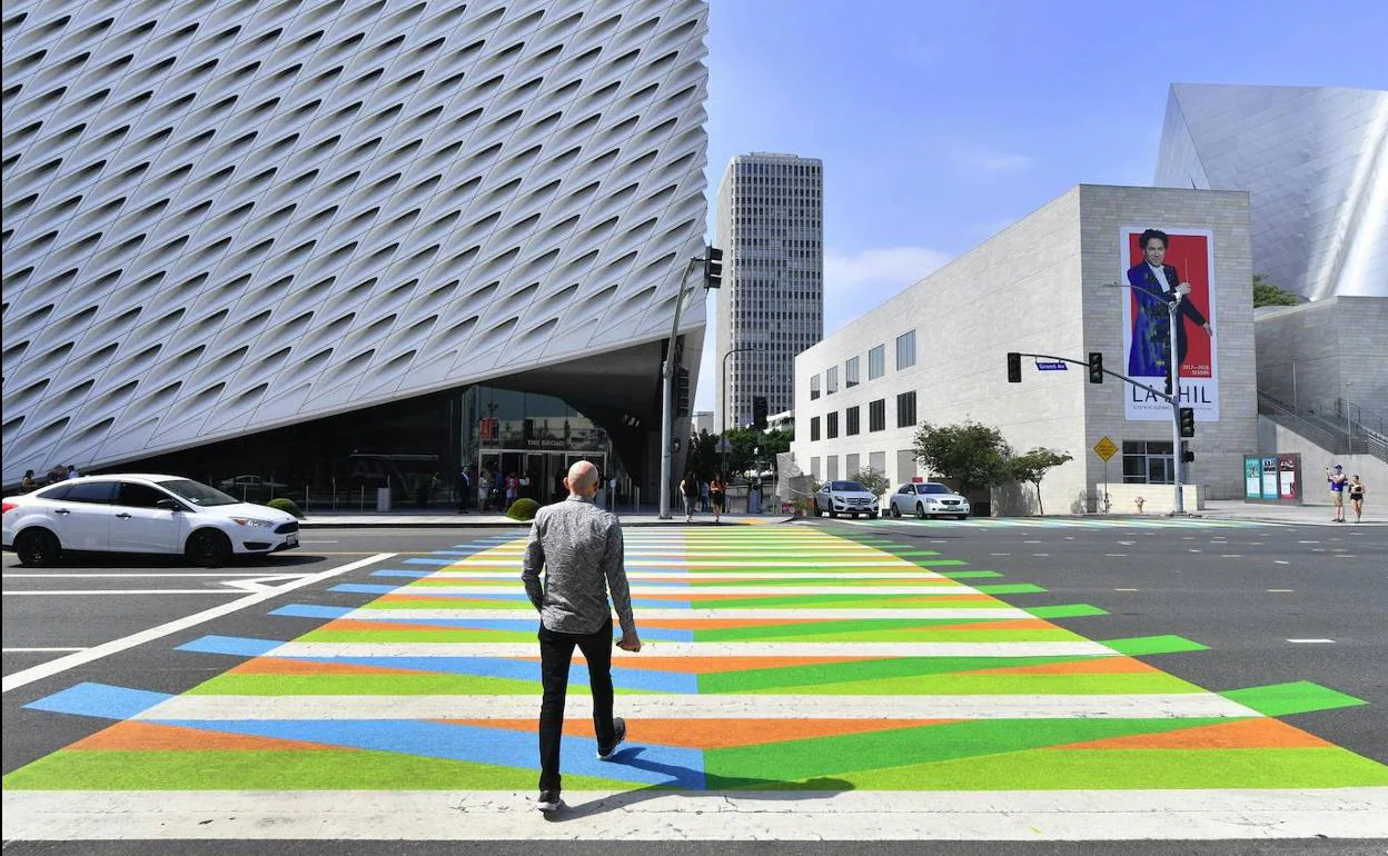 Un hombre cruza un paso de cebra pintado por el artista venezolano Carlos Cruz-Diez.