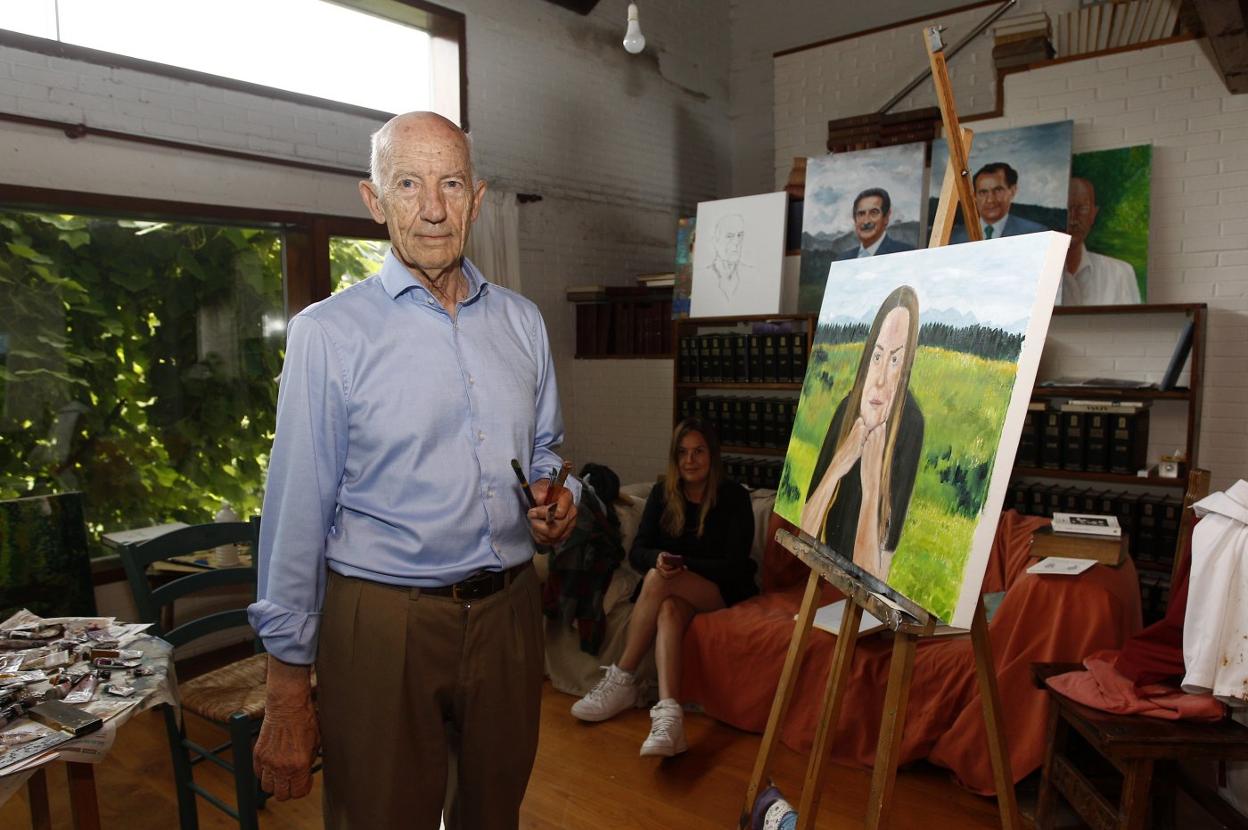 Pedro Crespo, delante de un retrato de la artista Berta Jayo, en su casa de Suesa, el lugar donde pinta.