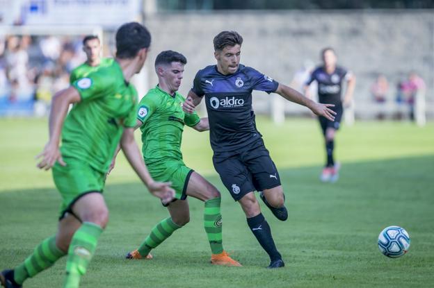 Martín Solar intenta controlar el balón ante dos jugadores del Cayón en el tercer partido de la pretemporada del Racing. 