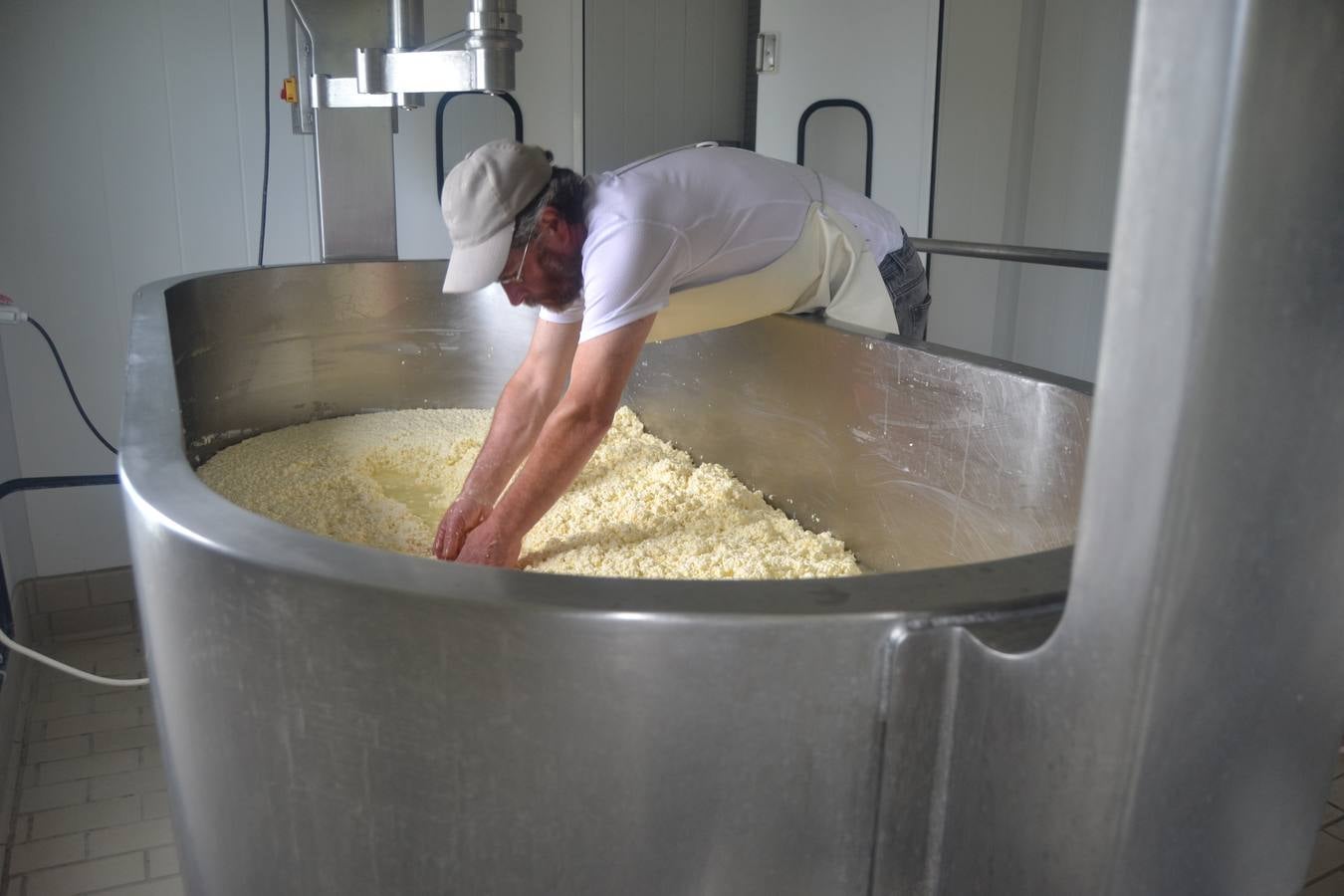 Javier Campo introduce manualmente la cuajada en los moldes para elaborar el queso.