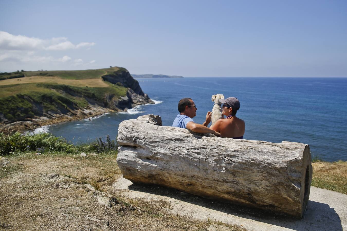 Una pareja con su perro sentados en el mirador de Los Remedios, en Liandres.