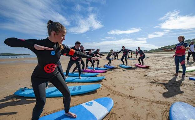 Alumnos de la Escuela Cántabra de Surf, en la playa de Somo, esta semana durante una clase de iniciación. 