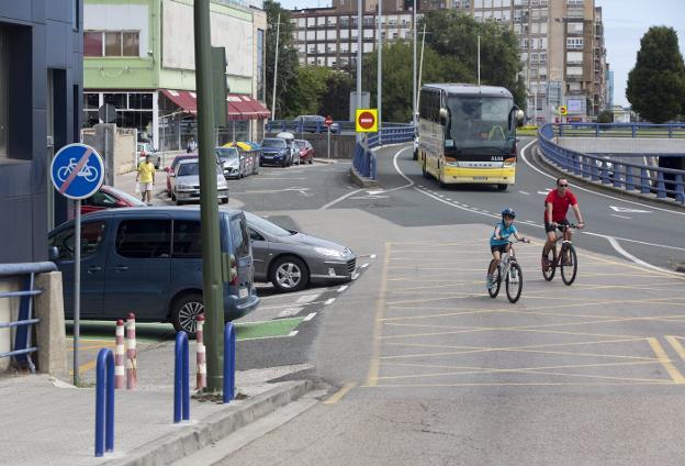 Dos ciclistas, uno de ellos un niño, avanzan por la carretera ante la ausencia de una vía ciclable en la Avenida de Parayas (Zona conflictiva 10).