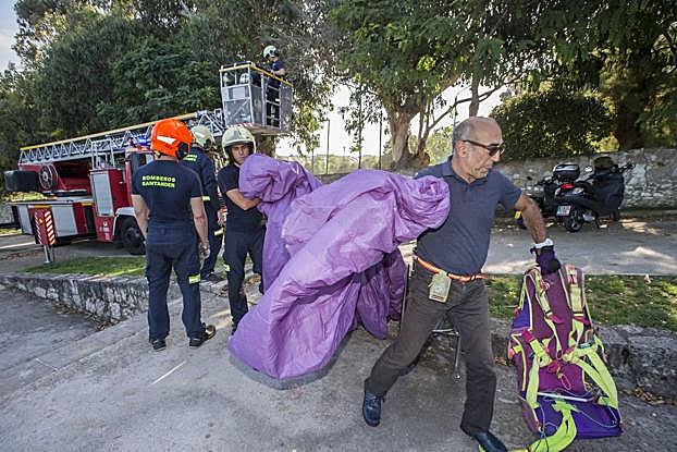 El parapentista, recogiendo su equipo después de ser rescatado.