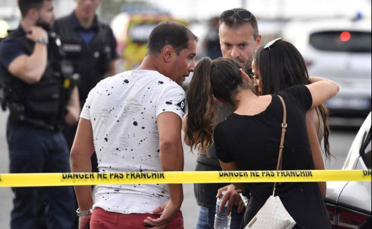 Un grupo de personas consuelan a una camarera que había presenciado el ataque en Lyon.