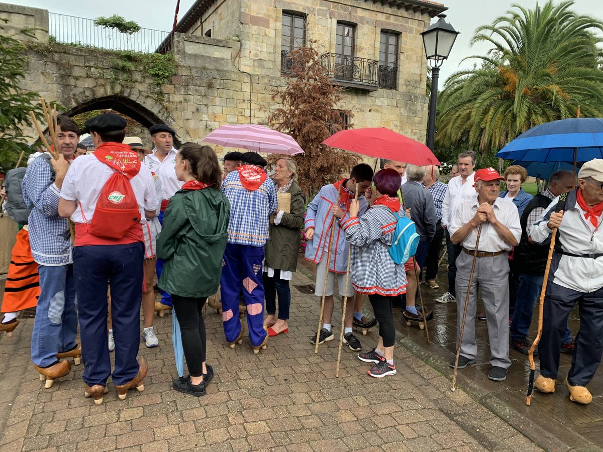 Los vecinos de Cartes tuvieron que sacar los paraguas para participar en el 'Día de las albarcas', caminando bajo la lluvia hasta Cohicillos