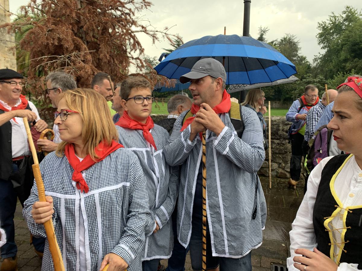 Los vecinos de Cartes tuvieron que sacar los paraguas para participar en el 'Día de las albarcas', caminando bajo la lluvia hasta Cohicillos