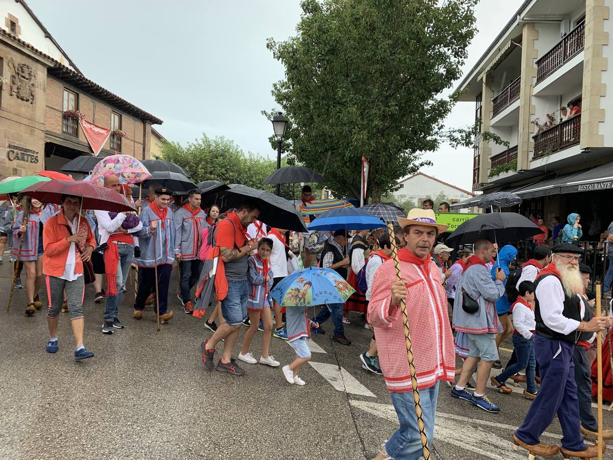 Los vecinos de Cartes tuvieron que sacar los paraguas para participar en el 'Día de las albarcas', caminando bajo la lluvia hasta Cohicillos