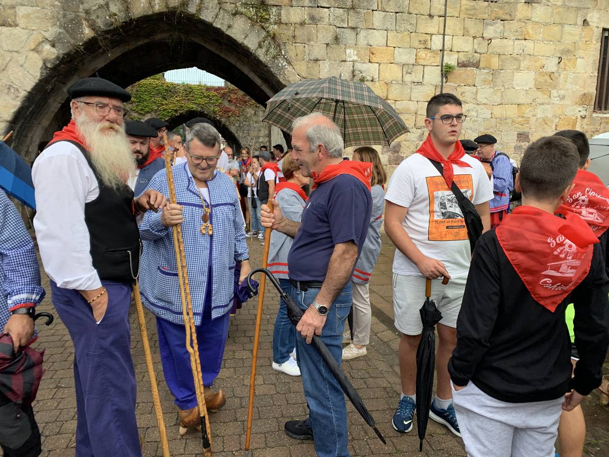 Los vecinos de Cartes tuvieron que sacar los paraguas para participar en el 'Día de las albarcas', caminando bajo la lluvia hasta Cohicillos