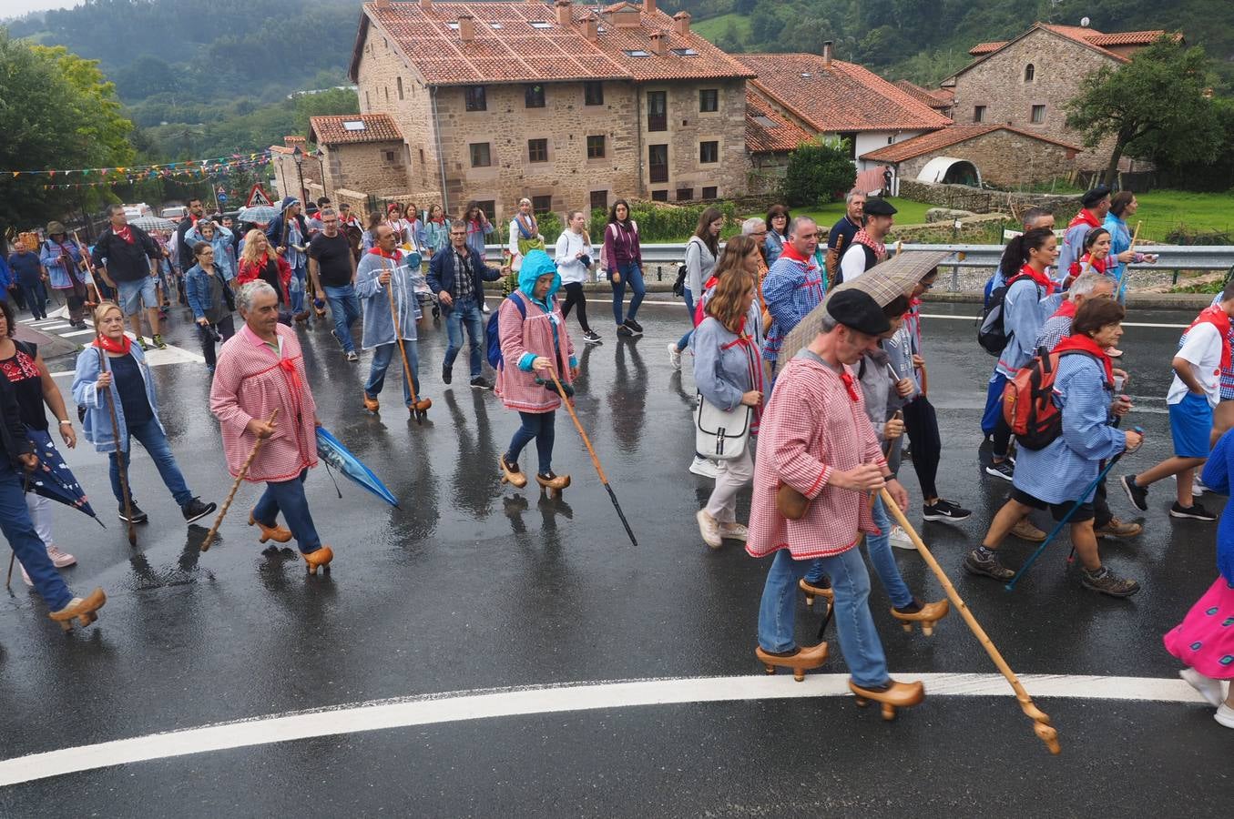Los vecinos de Cartes tuvieron que sacar los paraguas para participar en el 'Día de las albarcas', caminando bajo la lluvia hasta Cohicillos