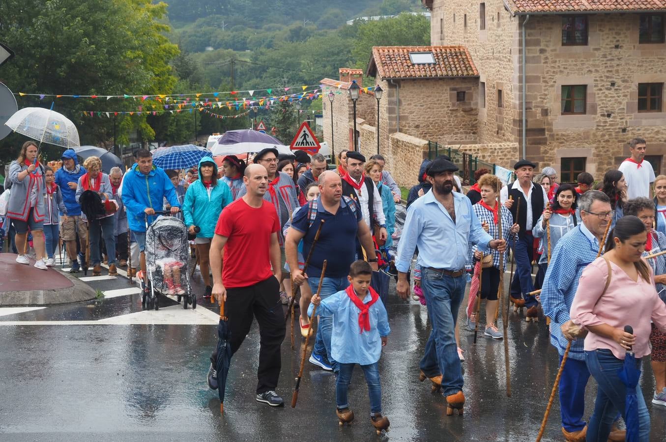 Los vecinos de Cartes tuvieron que sacar los paraguas para participar en el 'Día de las albarcas', caminando bajo la lluvia hasta Cohicillos
