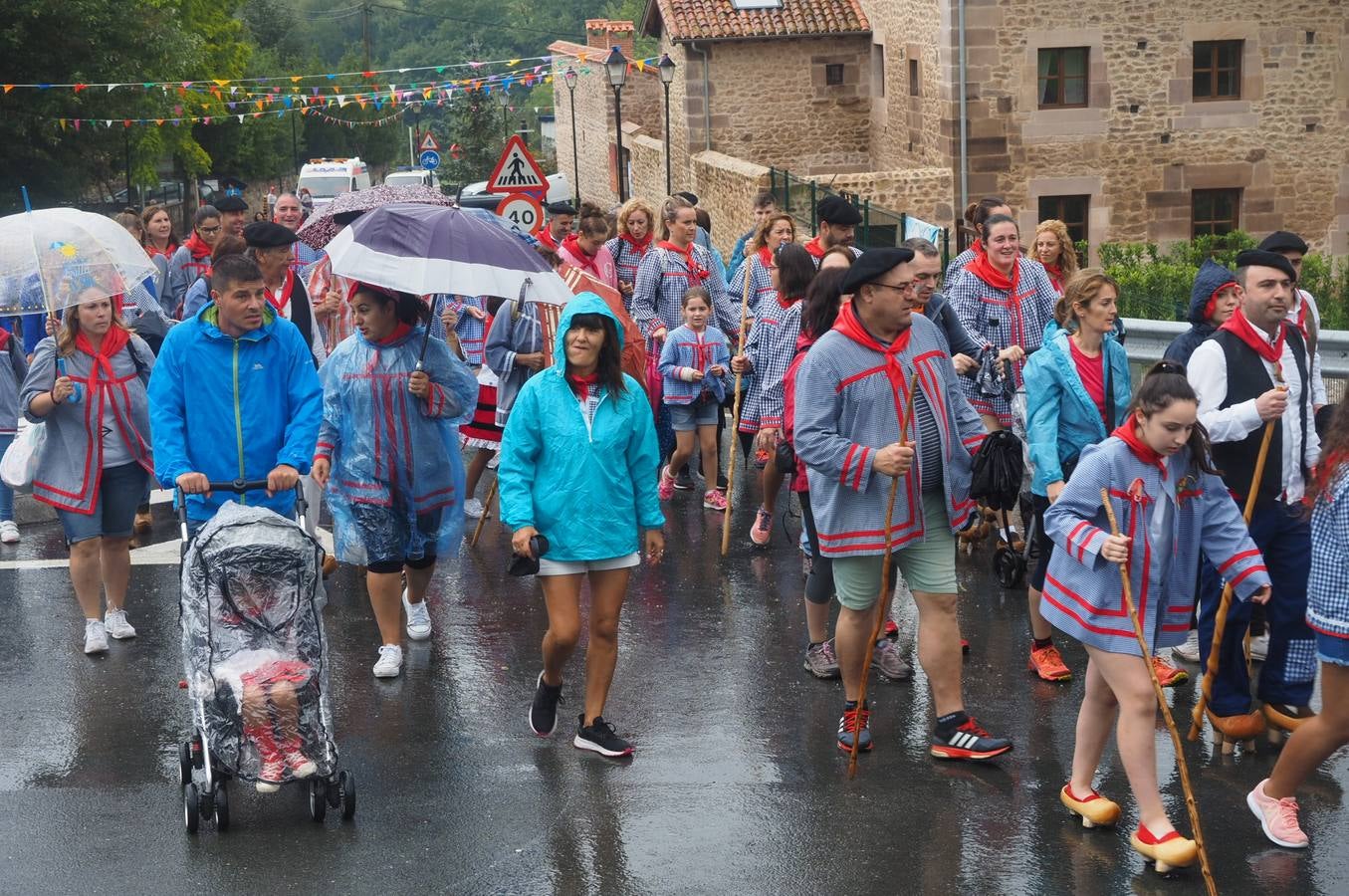 Los vecinos de Cartes tuvieron que sacar los paraguas para participar en el 'Día de las albarcas', caminando bajo la lluvia hasta Cohicillos