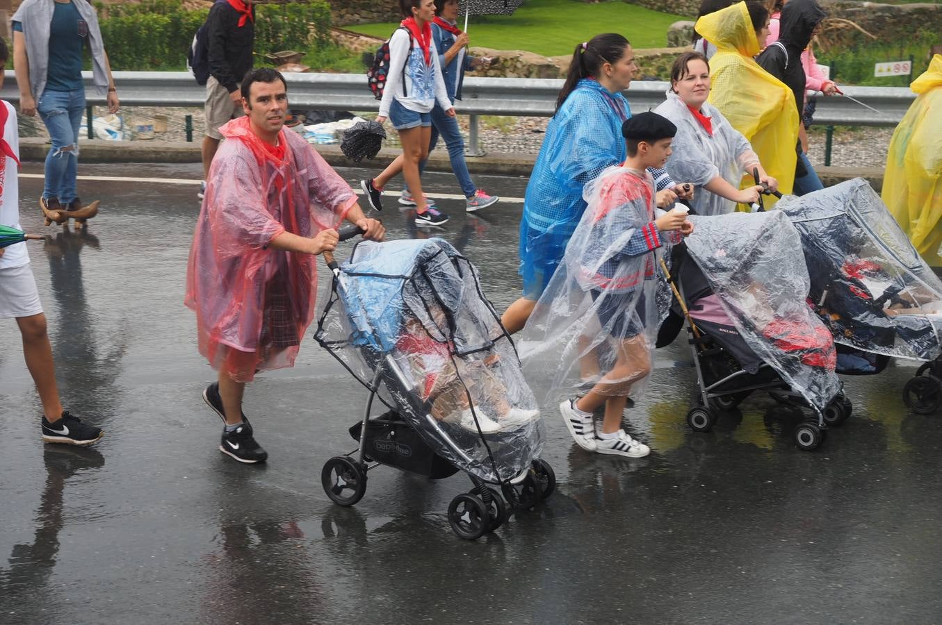 Los vecinos de Cartes tuvieron que sacar los paraguas para participar en el 'Día de las albarcas', caminando bajo la lluvia hasta Cohicillos