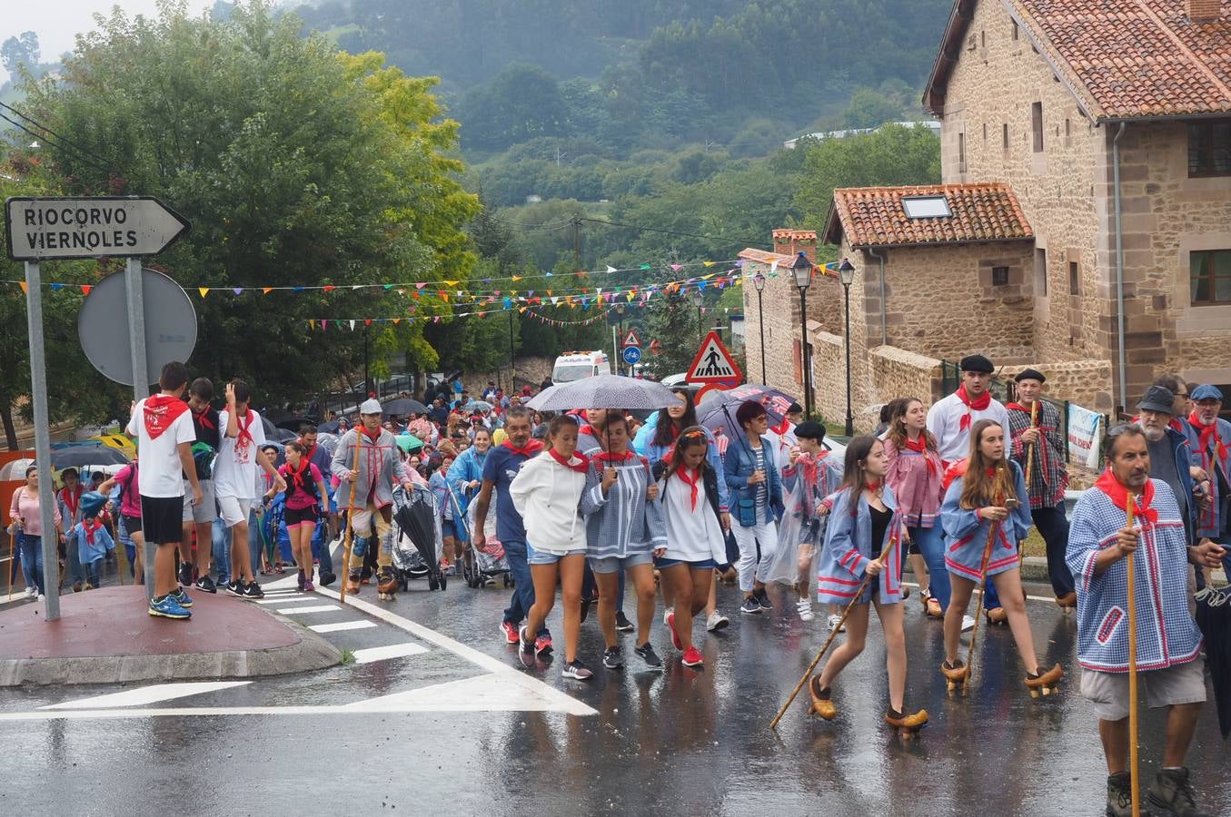 Los vecinos de Cartes tuvieron que sacar los paraguas para participar en el 'Día de las albarcas', caminando bajo la lluvia hasta Cohicillos