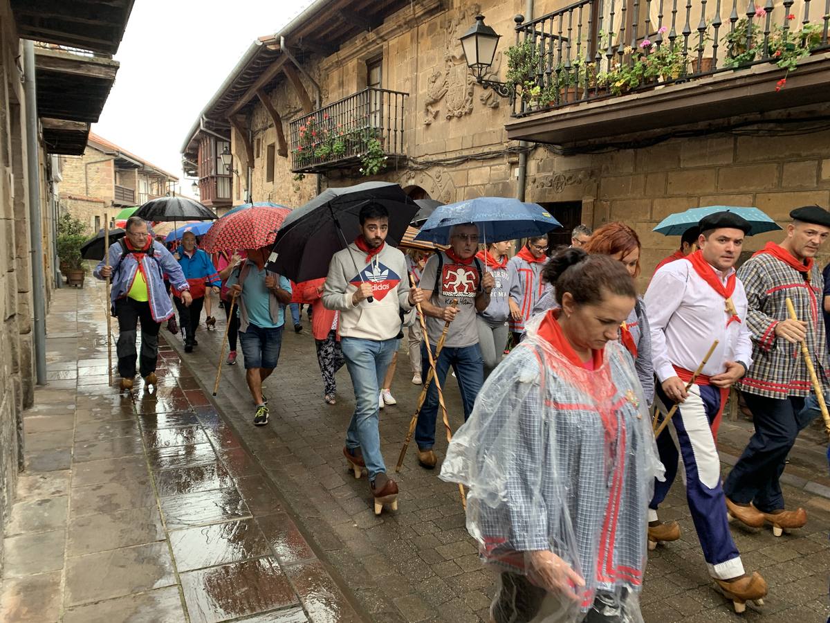 Los vecinos de Cartes tuvieron que sacar los paraguas para participar en el 'Día de las albarcas', caminando bajo la lluvia hasta Cohicillos