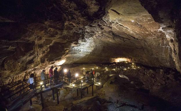 Un grupo de visitantes recorre la cueva de El Pendo en uno de los itinerarios guiados. :: celedonio