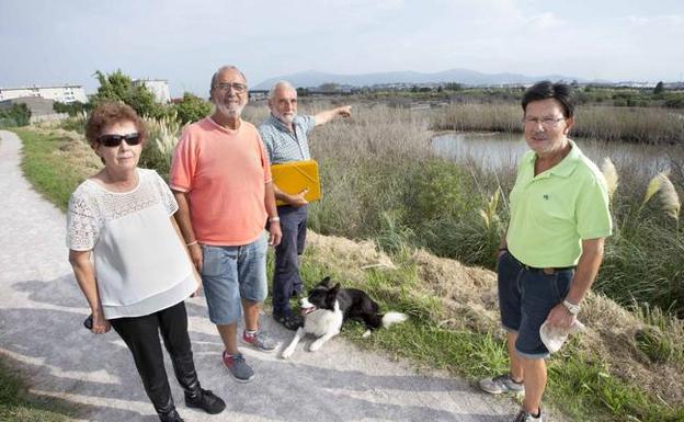 Un grupo vecinal muestra la zona de la ría donde se han detectado decenas de peces muertos. 