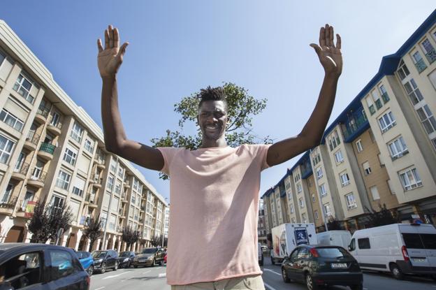 Nuha levanta los brazos, como si celebrara un gol, junto a la puerta de su casa, en el barrio de El Alisal, en Santander.