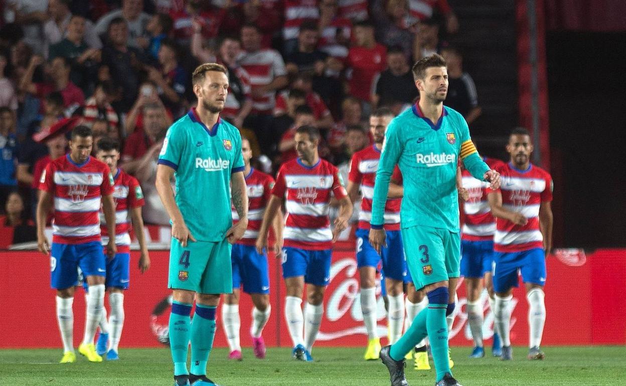 Rakitic y Piqué se lamentan tras uno de los goles del Granada.