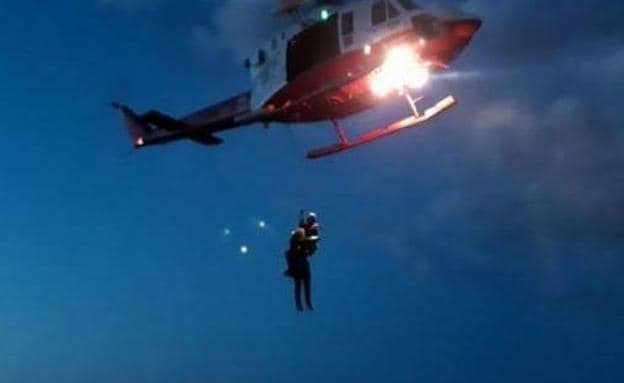 Momento en el que el helicóptero saca del acantilado al pescador. Uno de los agentes grabó con su teléfono la delicada operación