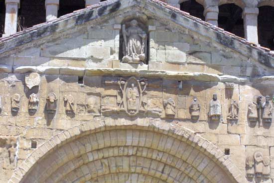 Imagen secundaria 2 - Vista de la colegiata de Santa Juliana y la Plaza de las Arenas. En primer término, el museo del escultor Jesús Otero. Vista frontal de la colegiata. Friso superior en la portada principal de la colegiata 