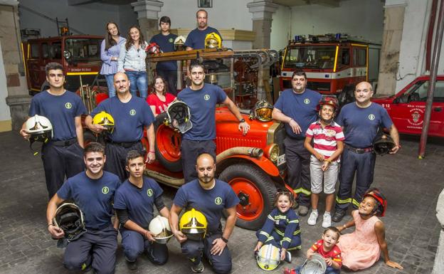 En la imagen, los bomberos voluntarios junto a esposas e hijos, posan en la sede de Numancia alrededor del clásico vehículo Dion Bouton. De izquierda a derecha, primera fila, Alejandro Santamaría, Alejandro Murillo, Alberto Pérez y los pequeños Candela, Álvaro y Coral. Segunda fila, de izquierda a derecha, Francisco Navarro, Roberto Revuelta, Beatriz Rodríguez,Jesús Calleja, Álvaro Gutiérrez y Martín Briondo, junto a Roberto, en medio de ambos. En la última fila, de izquierda a derecha, Lucía Díaz, Beatriz Calderón, Sergio Herrera y Álvaro Calleja.