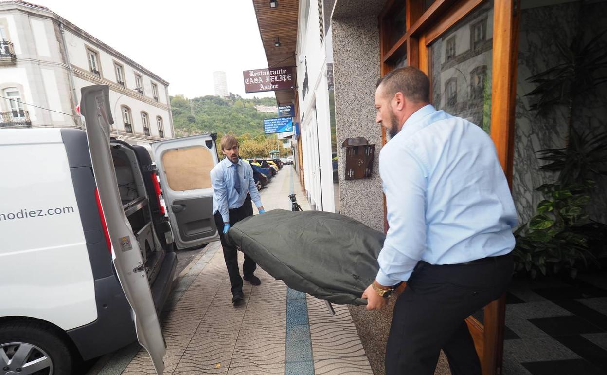 Trabajadores de la funeraria trasladan el cadáver del hombre.