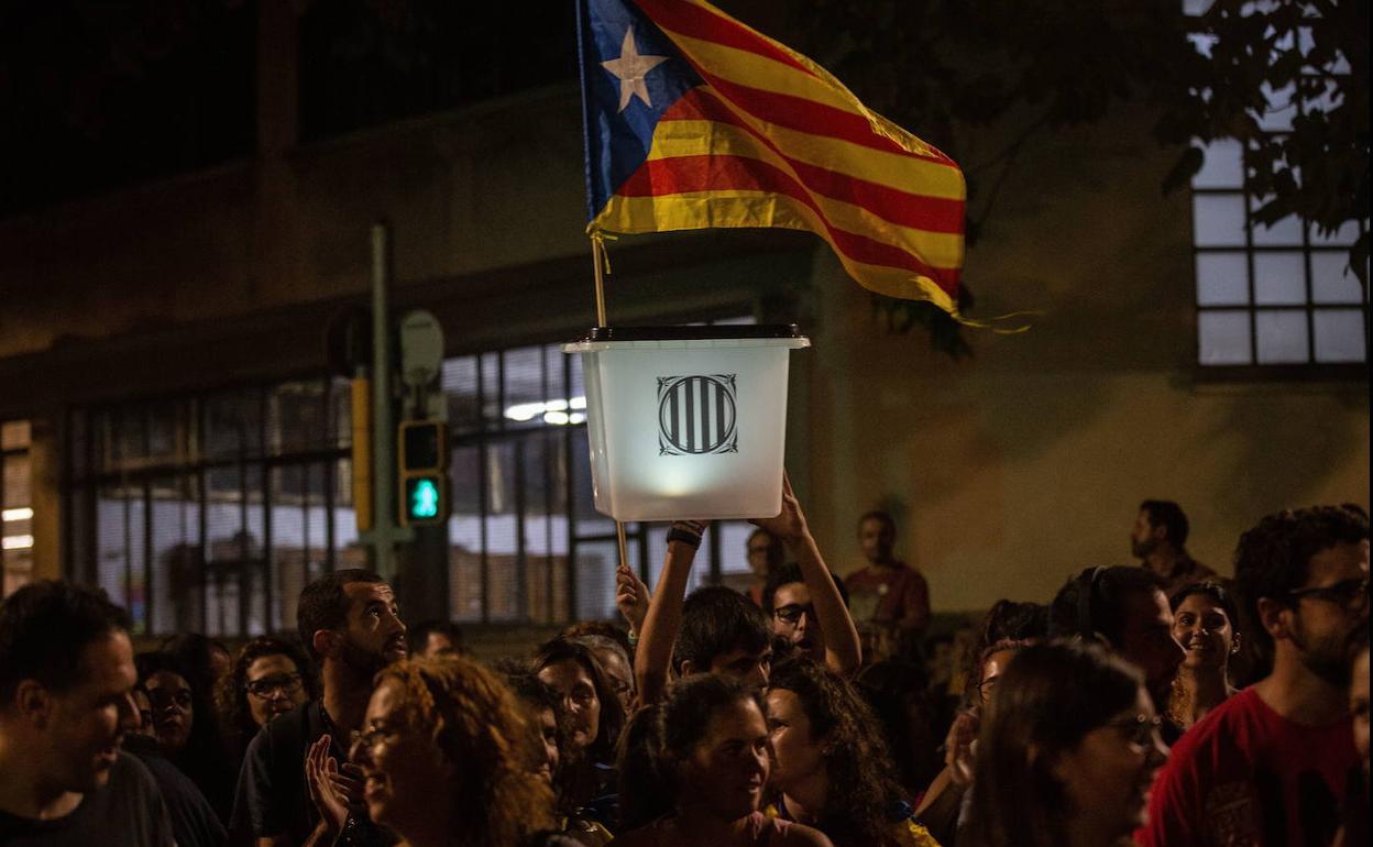 Un participante en la manifestación de la ANC por el segundo aniversario del 1-O con un cartel lleva una urna del referéndum 