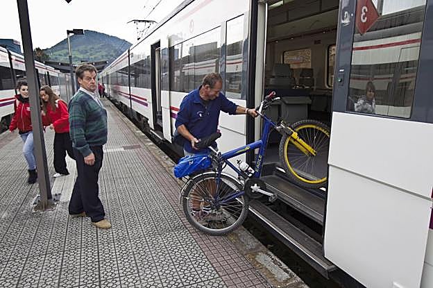 Imagen de archivo de viajeros junto a un Cercanías en la estación de Corrales de Buelna.