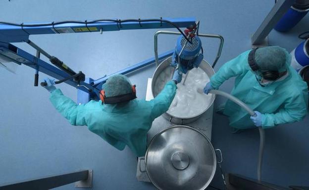 Dos empleados trabajan en el interior de la planta de producción de cosmética en el centro de Villaescusa. 