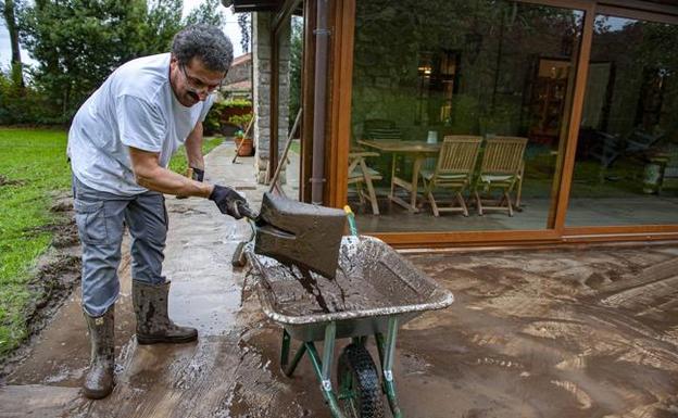 Vecino de Pesués limpiando su casa.