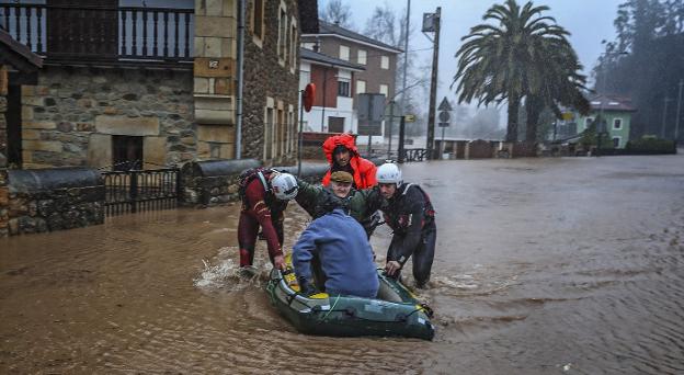 Un anciano es evacuado por los servicios de emergencia durante las inundaciones que sufrió Cantabria en enero.