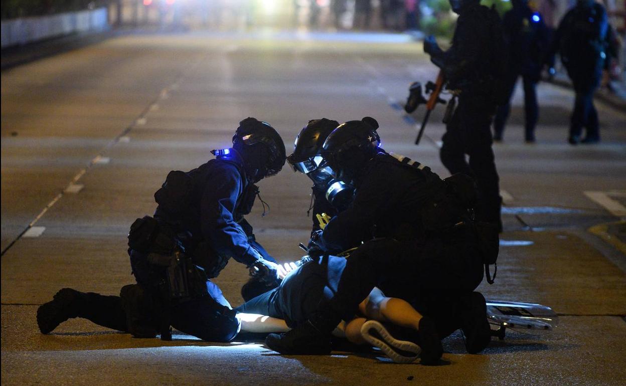 La Policía de Hong Kong detiene a un manifestante durante las protestas de este sábado.