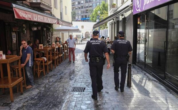 Una pareja de policía local recorre una calle peatonal de Santander. 