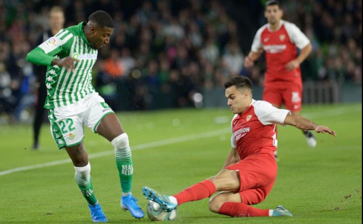 El bético Emerson pugna por un balón con el sevillista Reguilón. 