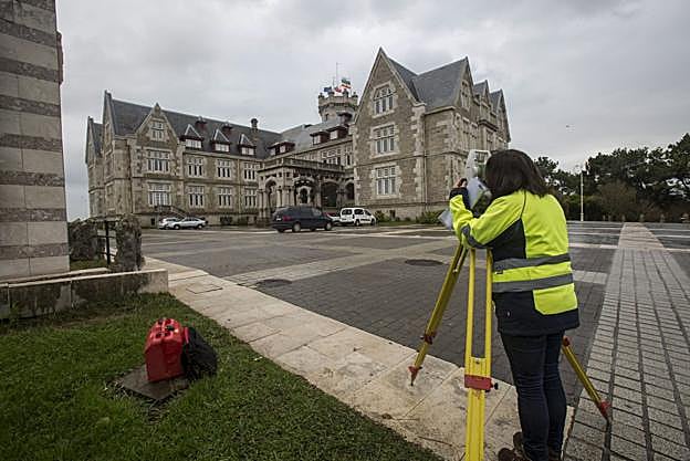Una operaria realiza mediciones de topografía en la explanada que se extiende frente al Palacio de La Magdalena.