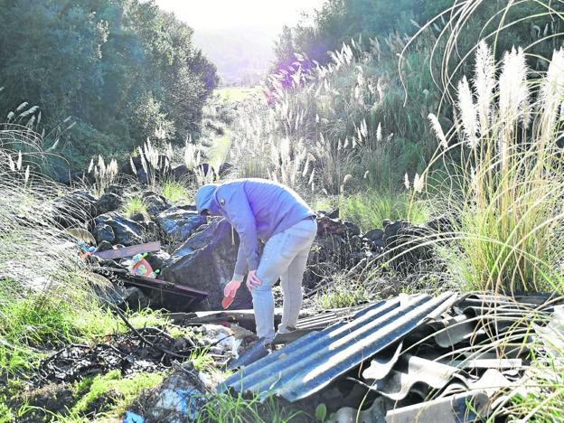 Un paseante examina los desechos acumulados en la senda, esta semana, en Revilla de Camargo. :: dm