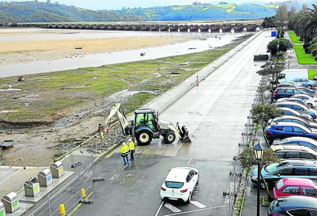 Una máquina comenzó ayer a levantar la acera del paseo marítimo para construir la nueva escollera. :