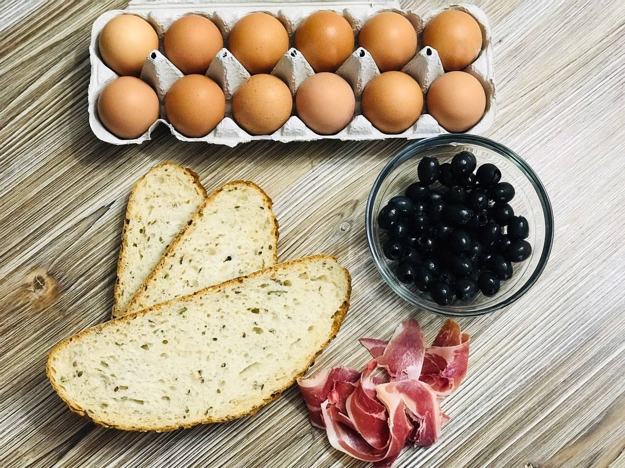 TORTILLA DIFERENTE. Ingredientes: Dos claras de huevo, una yema, una rebanada de pan rústico, aceitunas negras deshuesadas cantidad (20 aceitunas), una loncha de jamón serrano o ibérico, aceite de oliva virgen y sal opcional.