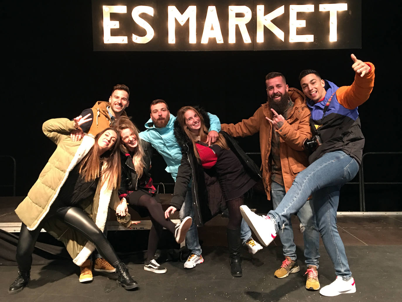 Grupo de amigos posa en el escenario principal con el cartel de #EsMarket.